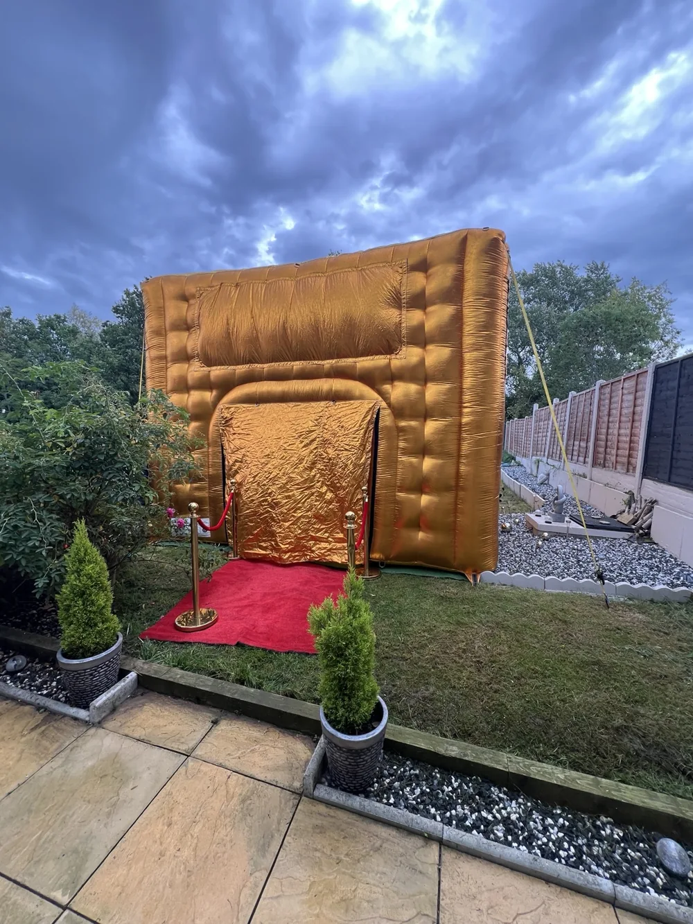 Gold inflatable nightclub with a red carpet entrance in a garden