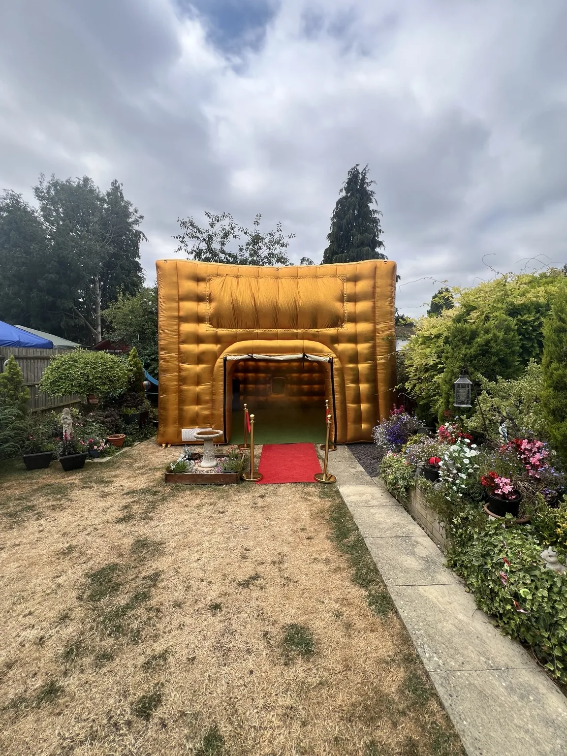 Gold inflatable nightclub with red carpet in a garden