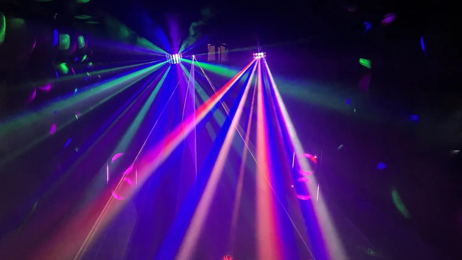 Multicoloured party lights and speakers inside the nightclub